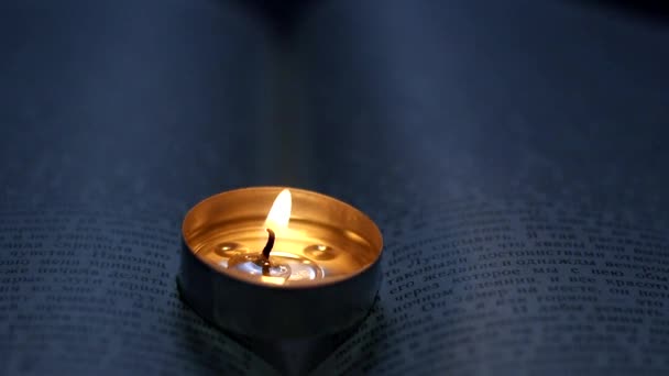 本の上でろうそくを燃やす ウクライナでの戦争による停電 — ストック動画