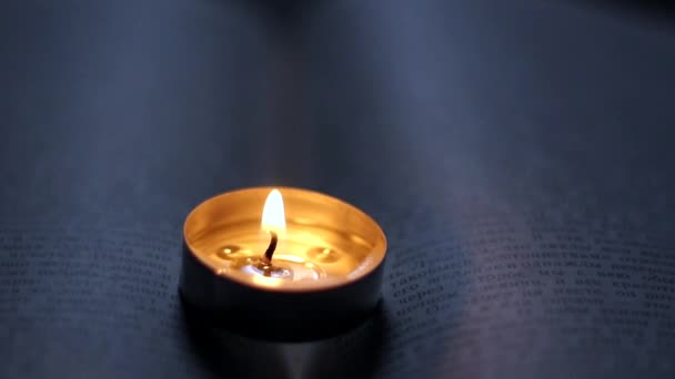本の上でろうそくを燃やす ウクライナでの戦争による停電 — ストック動画