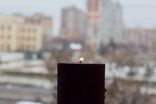 キエフの光のない複数階建ての建物の背景に燃えるろうそく ウクライナでの戦争による停電 — ストック写真
