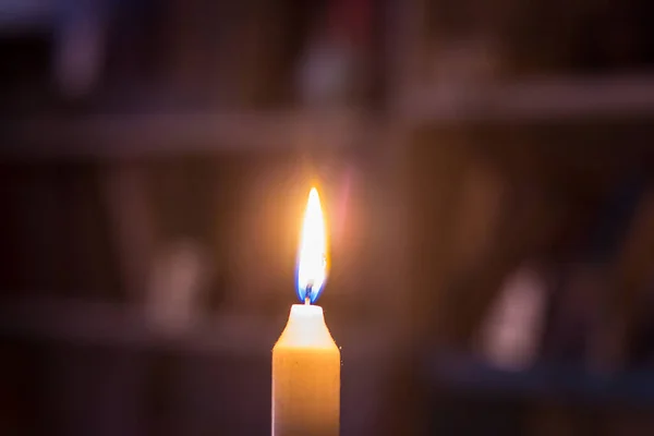 書棚を背景に本でろうそくを燃やす 戦争によるウクライナの停電 — ストック写真