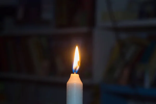 書棚を背景に本でろうそくを燃やす 戦争によるウクライナの停電 — ストック写真