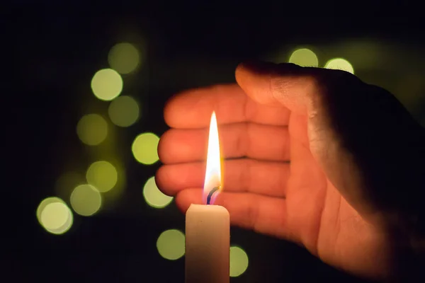 这只手关上了黑暗房间里蜡烛的火 乌克兰因战争而停电 — 图库照片