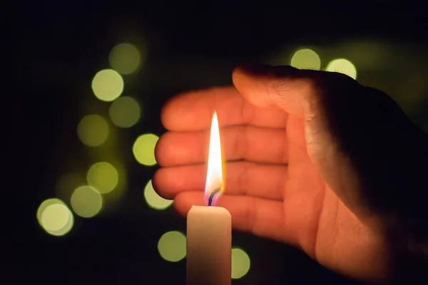 这只手关上了黑暗房间里蜡烛的火 乌克兰因战争而停电 — 图库照片