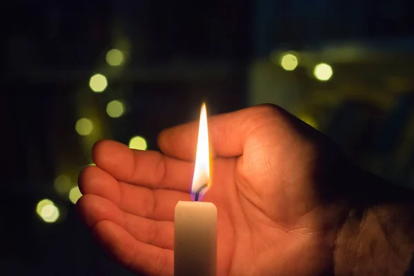 手は暗い部屋でろうそくの火を閉じます 戦争によるウクライナの停電 — ストック写真