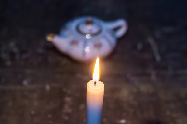 茶壶边的一支燃着的蜡烛 乌克兰因战争而停电 — 图库照片