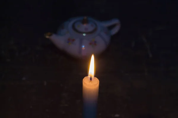 茶壶边的一支燃着的蜡烛 乌克兰因战争而停电 — 图库照片