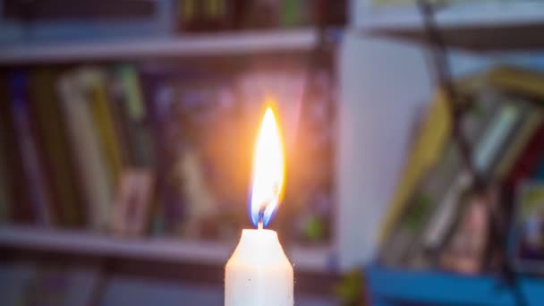 Brennende Kerze Auf Dem Hintergrund Von Regalen Mit Büchern Stromausfall — Stockvideo