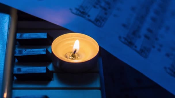 Lilin Yang Terbakar Pada Kunci Synthesizer Dekat Lembaran Dengan Catatan — Stok Video