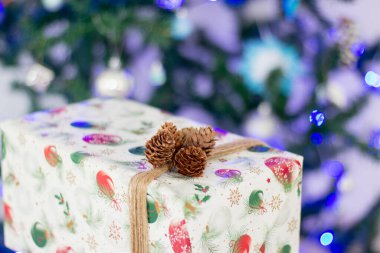 Yılbaşı hediyesi bir yılbaşı ağacının arka planındaki bir kutuda.