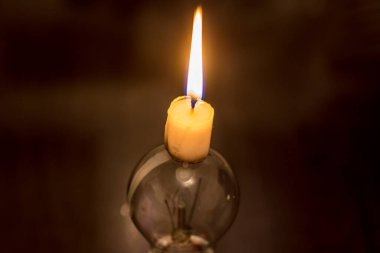 A burning candle and a broken lamp. Blackout due to war in Ukraine