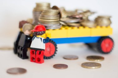 15.01.2023 Slovakia. Sala. Lego figures of different professions push a wagon with money.