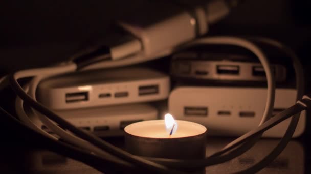 在电力银行和充电器的背景下燃烧着的蜡烛 乌克兰战争造成的停电 — 图库视频影像