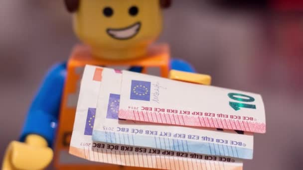 一个乐高公司的工人手里拿着欧元钞票 脸上带着欢乐的表情 — 图库视频影像