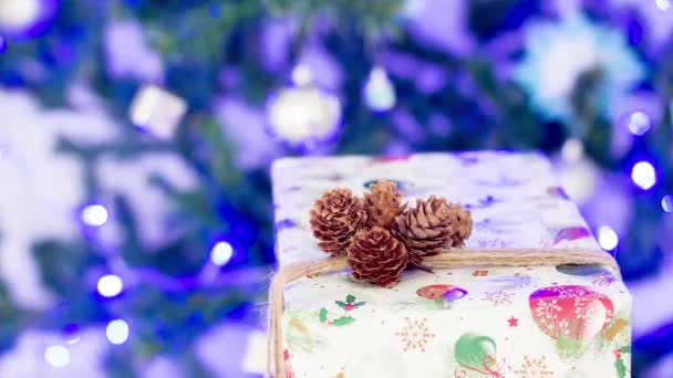 Neujahrsgeschenk Einer Schachtel Auf Dem Hintergrund Eines Weihnachtsbaums Mit Beleuchtung — Stockvideo