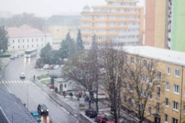 Flying snow in the winter on the background of the street