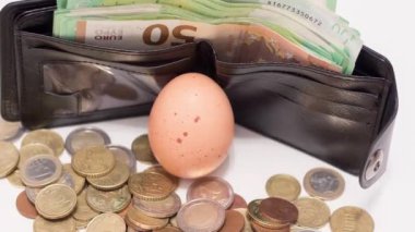 Chicken eggs near banknotes and coins. The rise in food prices due to the war in Ukraine