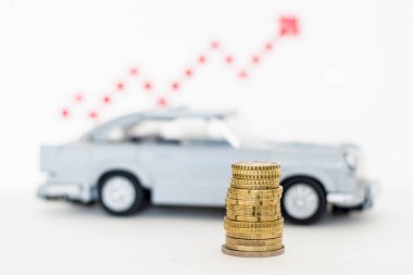  Lego car with coins on the background of sales growth arrows.
