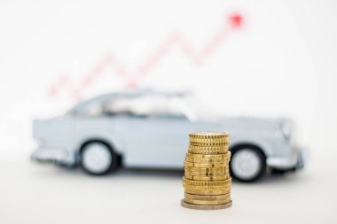 Lego car with coins on the background of sales growth arrows.