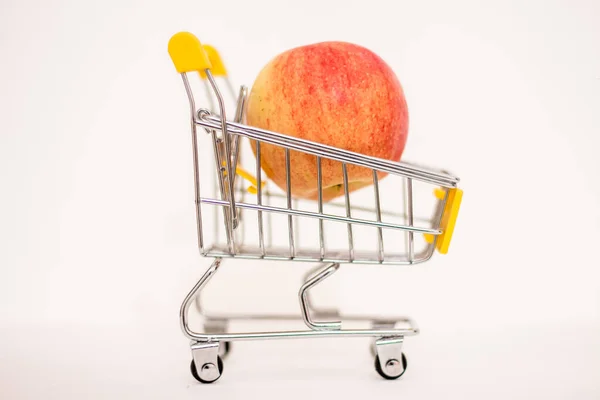 stock image One apple in a toy consumer basket. Inflation, rising food prices.