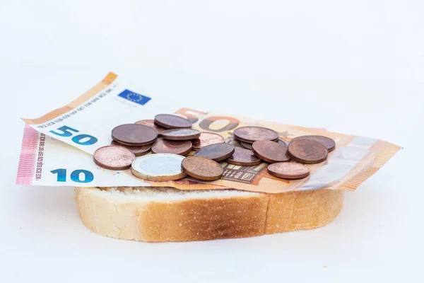 stock image Pieces of bread and coins with euro banknotes.