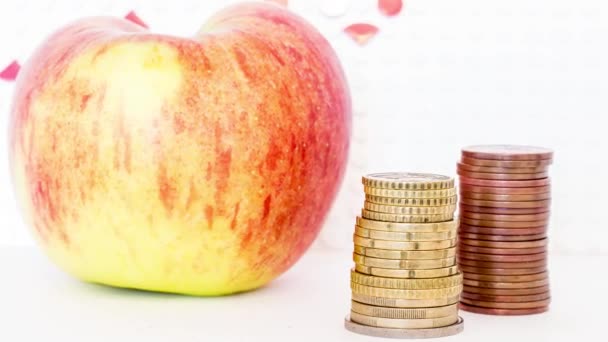 赤い成長矢印を背景にコインの列を持つリンゴ — ストック動画