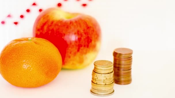 Mandarin Och Äpple Med Kolumner Mynt Mot Bakgrund Röd Tillväxt — Stockvideo