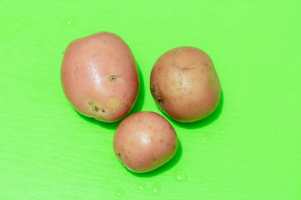 Três Batatas Uma Placa Verde — Fotografia de Stock