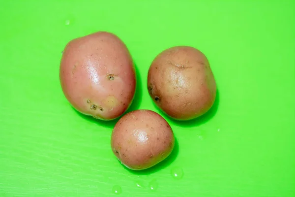 Три Картошки Зеленой Доске — стоковое фото