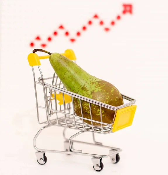 stock image A pear in a consumer basket against the background of a growth arrow. Increasing food prices.