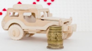 Wooden car with coins on the background of sales growth arrows.