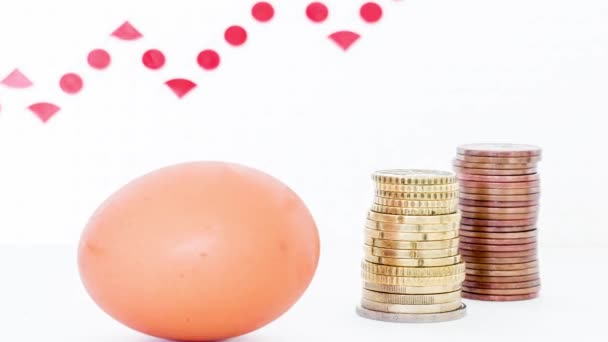 売上高の伸びの矢印を背景にコインの列を持つ鶏の卵 — ストック動画