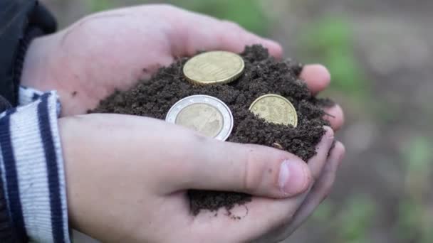 钱和泥土在孩子手里 — 图库视频影像