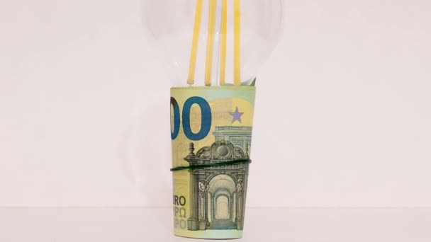電球がユーロ紙幣の束に挿入されます ウクライナでの戦争のためにヨーロッパでの価格の上昇 — ストック動画