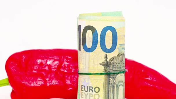 ユーロ紙幣と赤ピーマンを転がしました 白い背景で ウクライナでの戦争のためにヨーロッパでの価格の上昇 — ストック動画