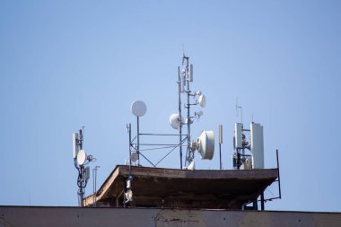 23.04.2023 Slovakya. Nove Zamky. Yüksek katlı bir binanın çatısında cep telefonu sinyalleri alan istasyonlar ve uydu anteni.