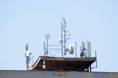 23.04.2023 Slovakya. Nove Zamky. Yüksek katlı bir binanın çatısında cep telefonu sinyalleri alan istasyonlar ve uydu anteni.