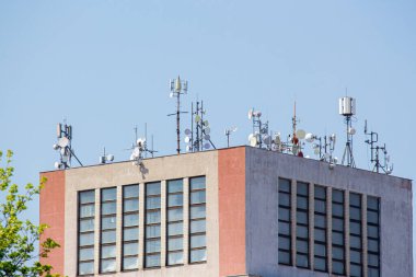 Cellular signal receiving stations and satellite dishes on the roof of a high-rise residential building