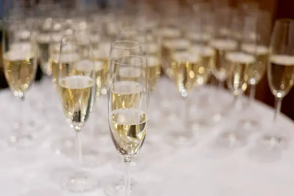 Lots of glasses of champagne on the buffet table.