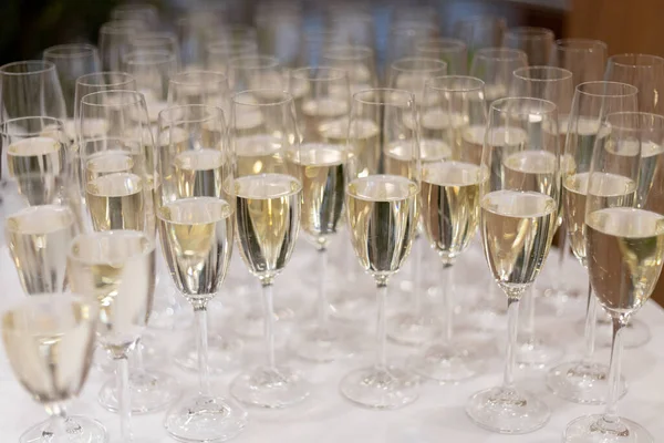 Lots of glasses of champagne on the buffet table.