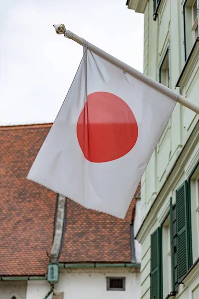 Japanese flag near a house in Europe close-up