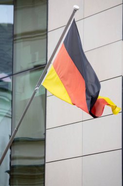 Modern bir binanın arka planında Almanya bayrağı