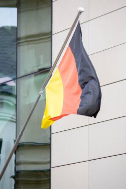 Modern bir binanın arka planında Almanya bayrağı