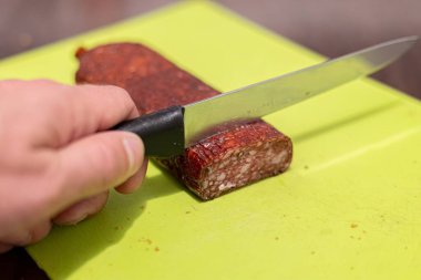 Yakından bıçakla sosis kesmek.