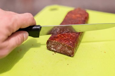 Yakından bıçakla sosis kesmek.