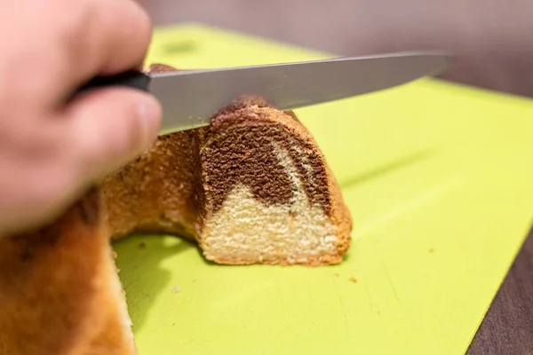 Cutting a cupcake with a knife in hand close-up