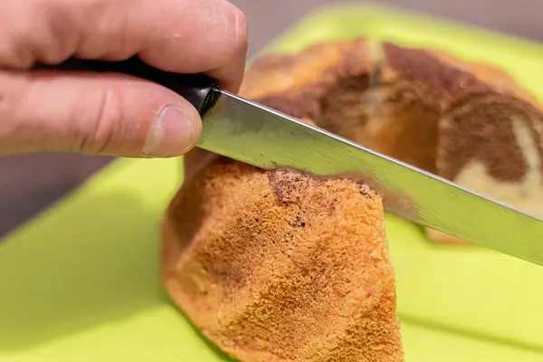 Cutting a cupcake with a knife in hand close-up