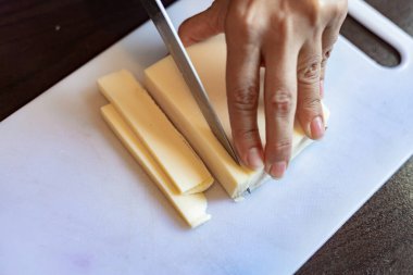 Peynir dilimleme. Yakın çekim.