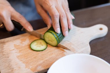 Yakından taze salatalık dilimliyorum.