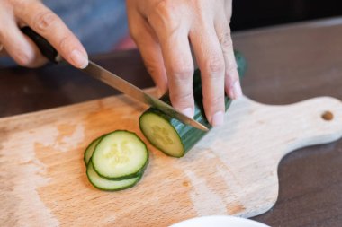 Yakından taze salatalık dilimliyorum.