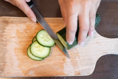Yakından taze salatalık dilimliyorum.